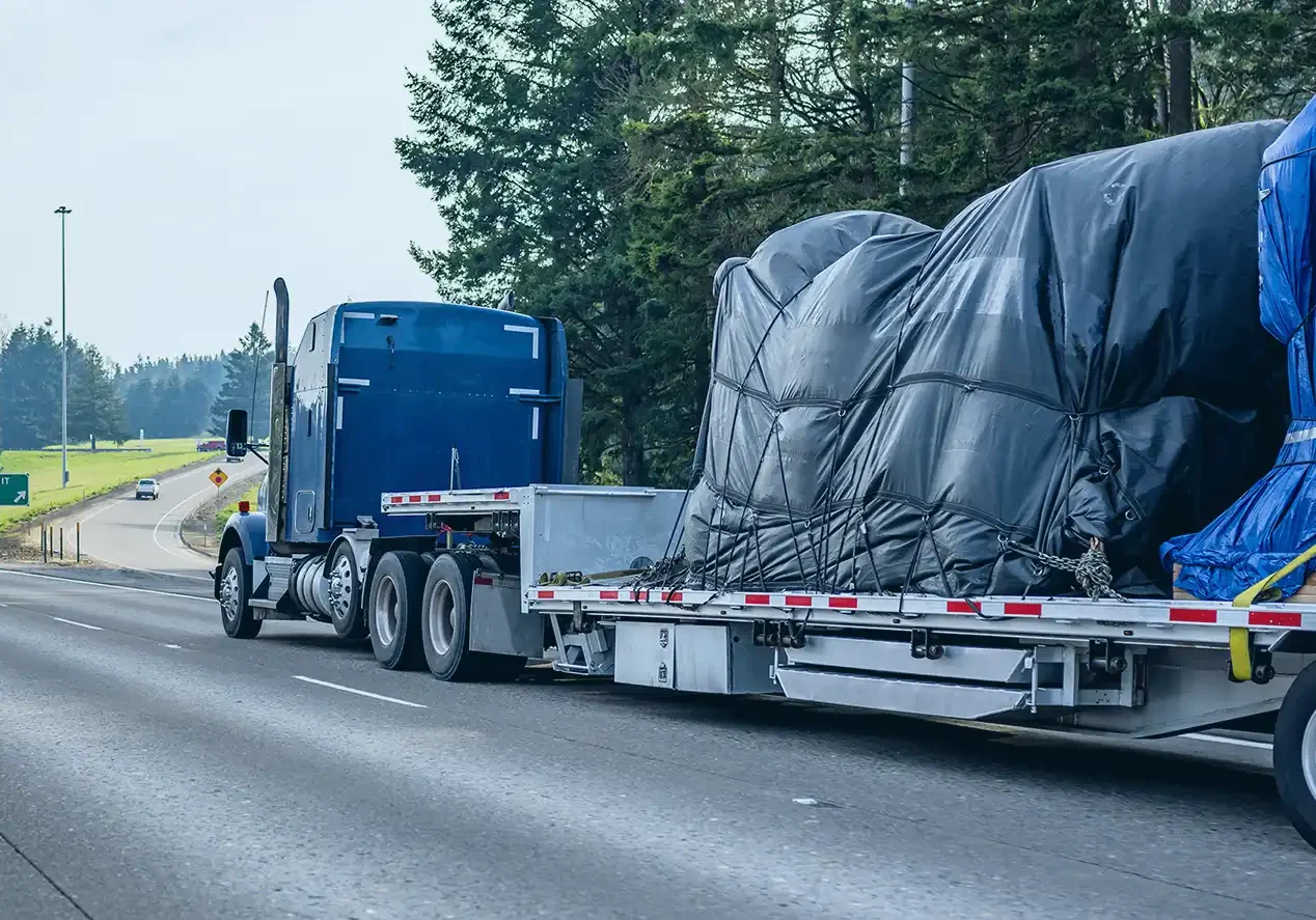 Semi-truck transporting machinery on highway