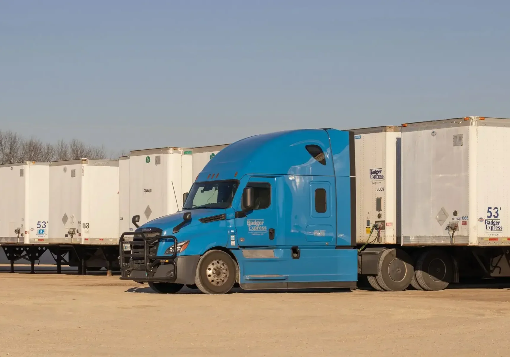Blue truck parked with white trailers